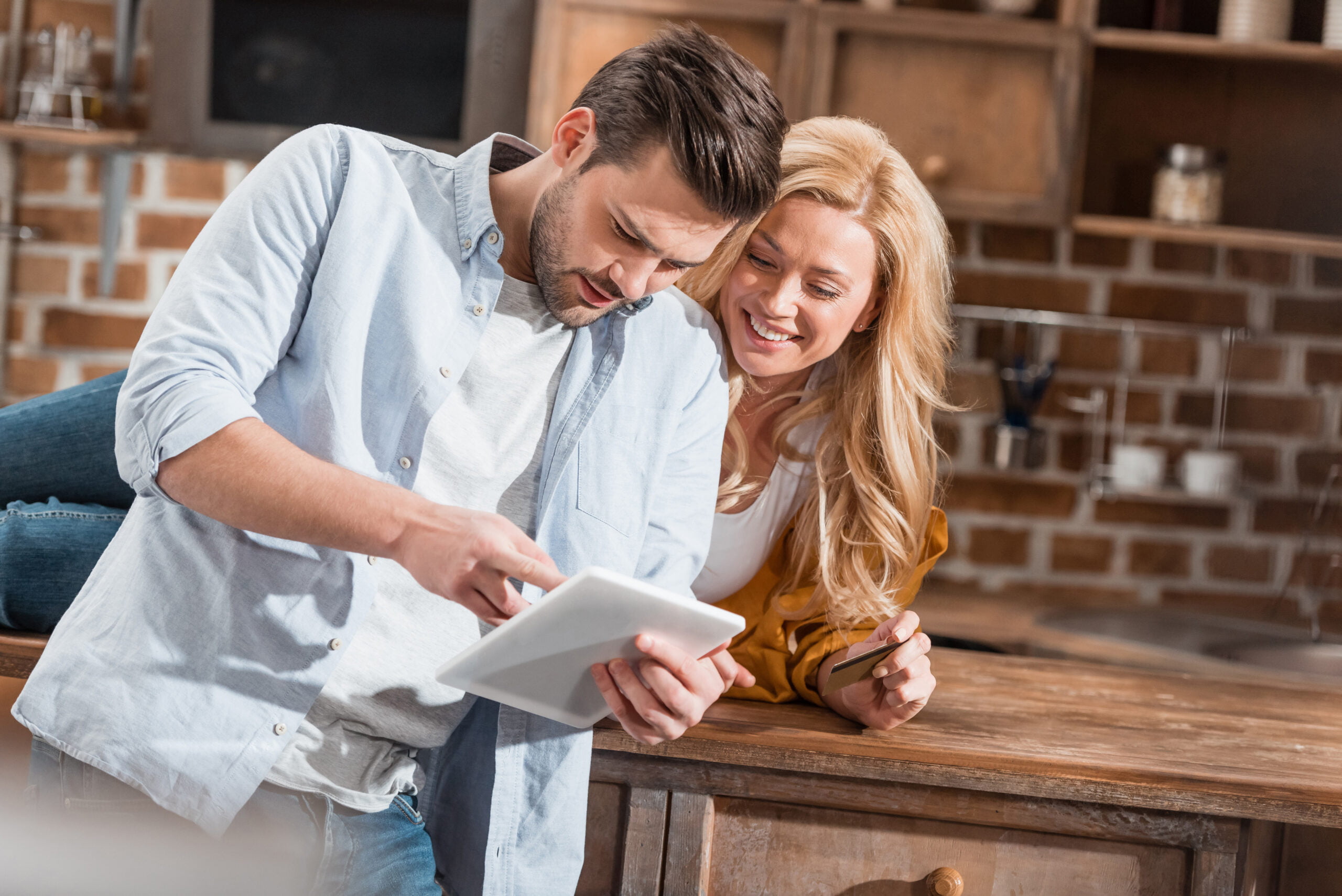young-couple-making-e-shopping-with-tablet-on-kitc-2022-11-02-02-48-52-utc-scaled.jpg